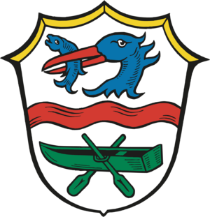 Bild vergrößern: Wappen der Gemeinde Rottach-Egern: Schild silbern, geteilt durch einen roten Querfluß, oben der Rumpf eines blauen Fischreihers mit einem Fisch im Schnabel, unten ein gründer Kahn mit zwei Rudern